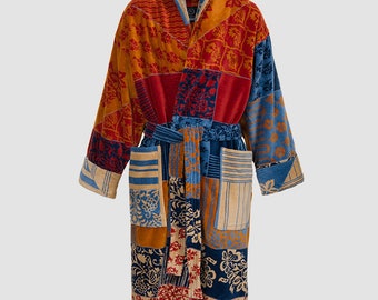 Puede incluir: Una bata larga y colorida con un diseño de patchwork que presenta varios patrones florales en tonos rojos, azules, naranjas y beige. La bata tiene un cuello chal, un cinturón de atar y dos bolsillos.