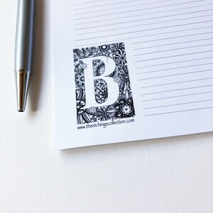 May include: Black and white illustration of the letter B surrounded by intricate floral designs. The image includes the text "www.theetchingscollection.com".