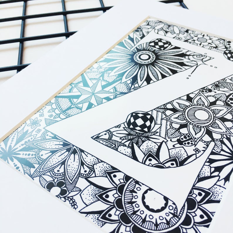 May include: A black and white illustration of the letter Z, surrounded by intricate patterns and designs. The letter is outlined in black and filled with white, while the surrounding patterns are filled with black and white.