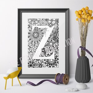 May include: Black and white printable art print featuring the letter Z surrounded by intricate floral designs. The letter Z is in a bold, sans-serif font.