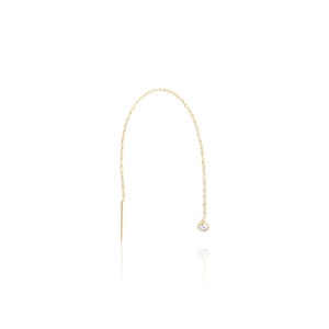 May include: A gold chain earring with a single clear gemstone at the end. The chain is delicate and has a simple design.