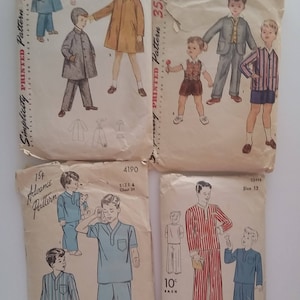 May include: Four vintage children's sewing pattern packets. The packets feature illustrations of boys in various outfits, including coats, suits, and pajamas. The packets are labeled with sizes and prices, and the brands are Simplicity, Advance, and D.B. Barry.