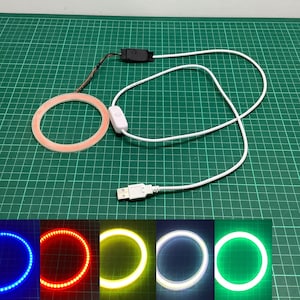 May include: A white USB-powered ring light with a switch and a white cord. The ring light is shown in five different colours: blue, red, yellow, white, and green.