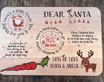 May include: Wooden Christmas serving board with festive illustrations and text. Features Santa Claus, a reindeer, a carrot, and the words "Dear Santa," "Milk for Santa," and "Lots of Love."