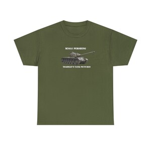 May include: A green t-shirt with a white print of a military tank with the text "M26A1 PERSHING" and "TOADMAN'S TANK PICTURES" on it.