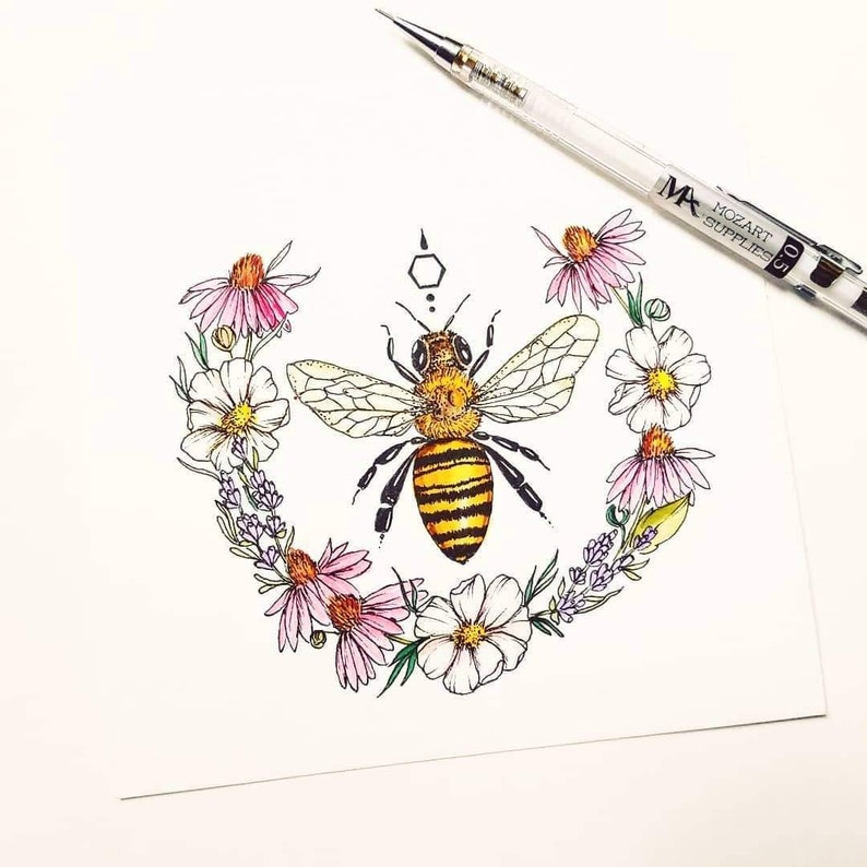 Puede incluir: Una ilustraci&oacute;n dibujada a mano de una abeja rodeada de una corona de flores rosas y blancas. La abeja es amarilla y negra con alas detalladas. Las flores est&aacute;n dibujadas en un estilo delicado con p&eacute;talos rosas y blancos.