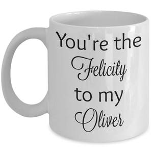 May include: White ceramic coffee mug with black text that reads "You're the Felicity to my Oliver".