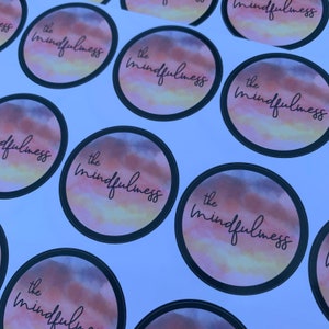 May include: Multiple round stickers with a watercolor design in shades of pink, orange, and yellow. The text "the mindfulness" is written in black cursive on each sticker.