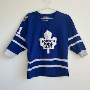 May include: A blue and white Toronto Maple Leafs hockey jersey with the team logo and the number "1" on the front.