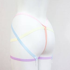 May include: A pastel-colored garter belt with a light blue, yellow, pink, and purple ribbon design.
