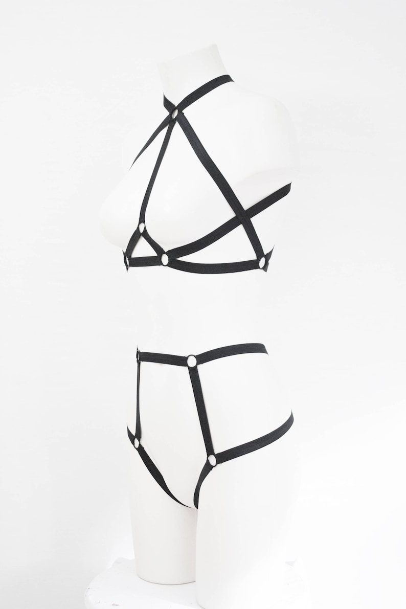 May include: Black lingerie set with straps and metal rings. The set includes a bra and a panty.