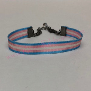 May include: A blue, pink, and white striped ribbon bracelet with a silver chain clasp.