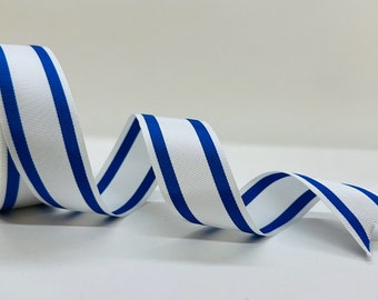 May include: White and blue striped ribbon with a blue stripe on each side of the white stripe. The ribbon is rolled up on a spool.