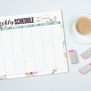 May include: A floral-decorated weekly schedule with the title "Weekly Schedule" in a handwritten font. A cup of coffee and three decorative erasers are next to the schedule. The erasers have pink and gold patterns.
