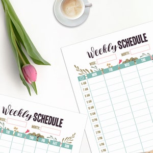 May include: Two "Weekly Schedule" printable sheets with floral accents and a teal and pink color scheme. A pink tulip and green leaves are on the left. A cup of coffee, a keyboard, and scissors are also visible.