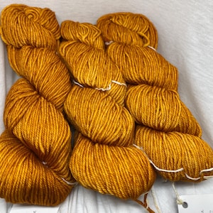 May include: A skein of golden yellow yarn, perfect for knitting or crocheting projects.