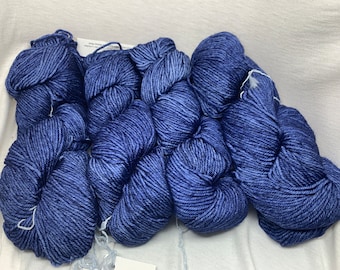 Könnte beinhalten: Vier Knäuel blauer Wolle, jedes Knäuel ist zu einer Kugel gewickelt.