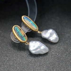May include: A pair of gold earrings with iridescent opal stones and white baroque pearls.