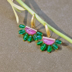 May include: A pair of gold earrings featuring pink and green gemstones. The earrings have a crescent-shaped pink stone with a row of diamonds, surrounded by a cluster of green gemstones.