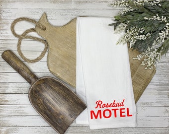 Könnte beinhalten: Weißes Küchentuch mit rotem Sticktext "Rosebud Motel".