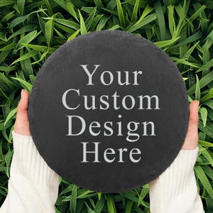 May include: A black slate round serving tray with the text "Your Custom Design Here" in white lettering.