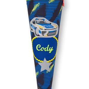 Könnte beinhalten: Ein blauer und schwarzer Schultüte mit einem gelben Stern und einem Polizeiauto-Design. Die Tüte trägt den Namen "Cody".