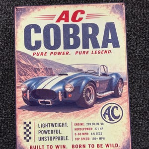 May include: A rectangular metal sign featuring a blue AC Cobra sports car with white racing stripes. The text reads AC COBRA, PURE POWER. PURE LEGEND., LIGHTWEIGHT. POWERFUL. UNSTOPPABLE., ENGINE: 289 CU. IN. V8, HORSEPOWER: 271 HP, 0-60 MPH: 4.6 SECS, TOP SPEED: 150+ MPH, BUILT TO WIN. BORN TO BE WILD.