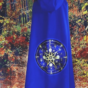 May include: A royal blue hooded cape with a large circular design on the back. The design features a five-pointed star, moons, and astrological symbols in gold.
