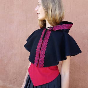 Cape, capuchon, kleine cape met capuchon omzoomd met rode veter of vlechtwerk. Victoriaanse, middeleeuwse... Cape Diem-stijl