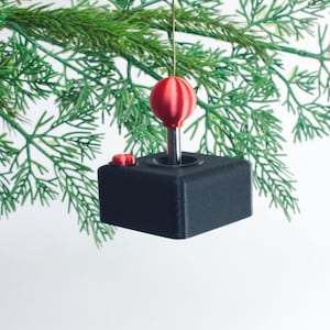 May include: A black and red 3D printed joystick ornament, ideal for a gamer's Christmas tree.