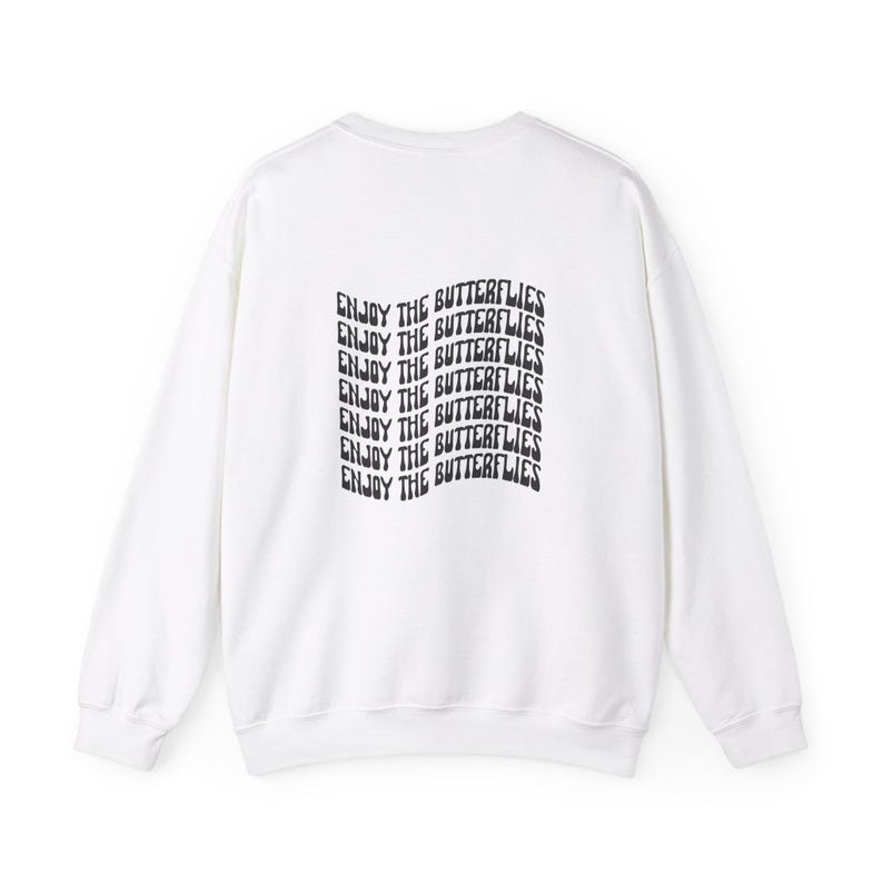 May include: White sweatshirt with a black graphic print that says "Enjoy the Butterflies" repeated multiple times.
