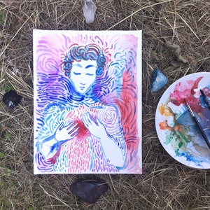 Peut inclure: Peinture à l'aquarelle d'une personne avec des tourbillons bleus et roses autour d'elle, tenant ses mains sur sa poitrine. La peinture est sur un fond blanc et il y a une assiette blanche avec de la peinture à l'arrière-plan.