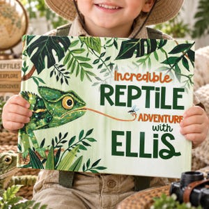 May include: A hardback book titled Incredible REPTILE ADVENTURE with ELLIS, featuring a green chameleon with a long tongue catching a fly, set against a background of illustrated tropical leaves in shades of green and dark forest tones.