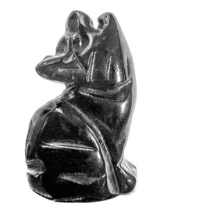 Puede incluir: Escultura de un ángel arrodillado en obsidiana negra con las alas extendidas. La escultura está tallada en detalle y tiene un acabado liso y pulido.