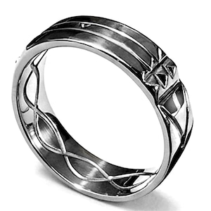 Op de afbeelding: Een zilveren ring met een gedetailleerd ontwerp. De ring heeft een reeks parallelle lijnen over de bovenkant en een ingewikkeld patroon aan de zijkanten. De ring heeft een gepolijst, reflecterend oppervlak.
