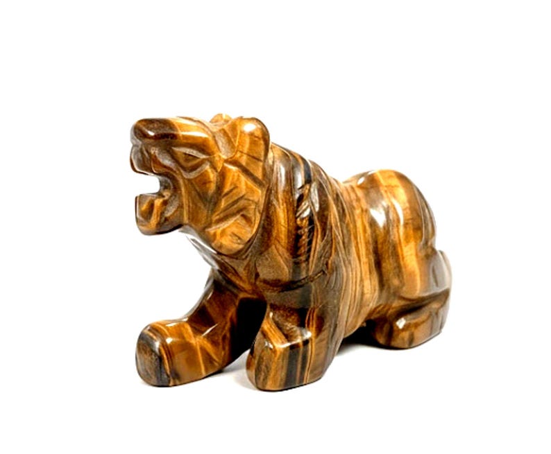 May include: A tiger's eye stone carving of a tiger in a roaring stance. The figurine features detailed carving of the tiger's fur and facial features. The stone has brown and gold bands.