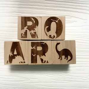 以下が含まれることがあります： 各ブロックに恐竜のシルエットが描かれた、ROARと綴られた木製のブロックです。