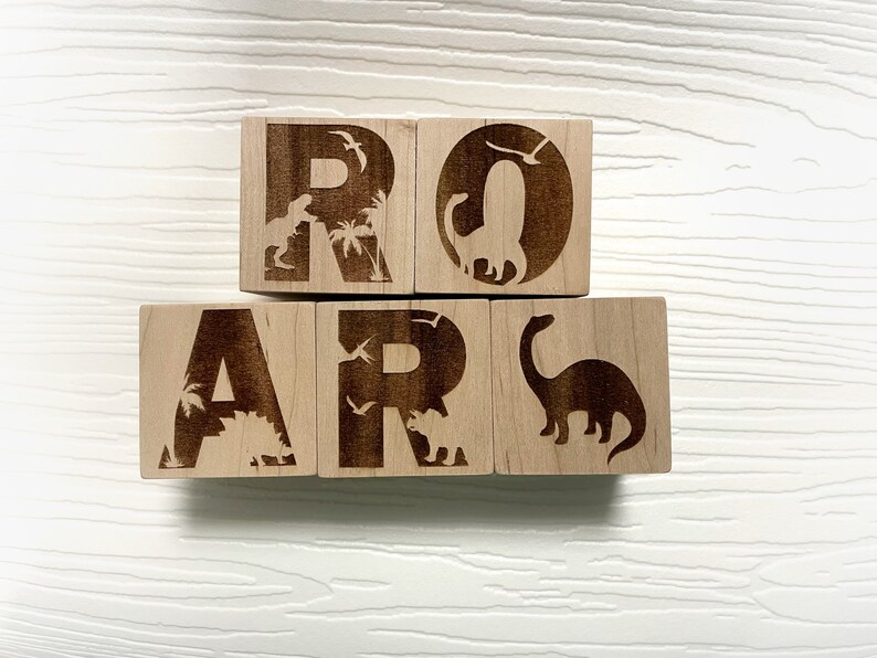 以下が含まれることがあります： 各ブロックに恐竜のシルエットが描かれた、ROARと綴られた木製のブロックです。