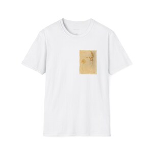 Puede incluir: Camiseta blanca de manga corta con un pequeño bolsillo cuadrado de color marrón claro en el pecho. El bolsillo tiene un diseño abstracto descolorido. La camiseta tiene cuello redondo y un diseño simple y minimalista, adecuado para ropa informal.