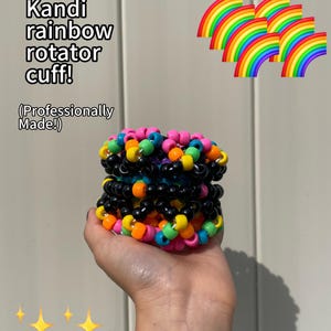 May include: A Kandi rainbow rotator cuff bracelet made with black, pink, orange, yellow, green, and blue beads. The text in the image says "Kandi rainbow rotator cuff! (Professionally Made!)". Rainbow graphics and star graphics are also in the image.