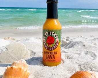 Może przedstawiać: Szklana butelka sosu Bohica Hot Sauce Hawaiian Lava z czarną nakrętką. Etykieta zawiera grafikę czerwonej papryczki chili oraz napis Bohica Hot Sauce Hawaiian Lava Net Wt 5 fl. oz. (147ml). Butelka stoi pionowo w białym piasku.