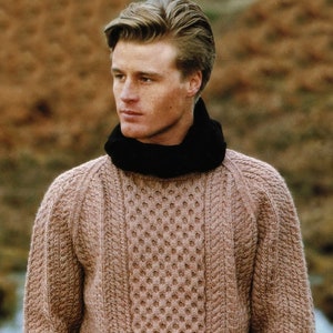May include: A brown knitted sweater with a cable knit pattern and a textured design. The sweater has a crew neck and long sleeves.