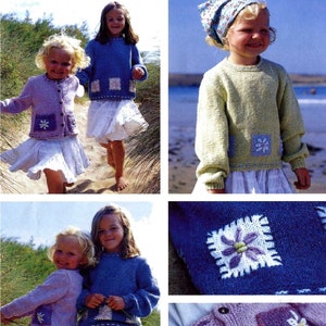 Può includere: Set di maglieria per bambini con un cardigan lilla chiaro e un maglione blu, entrambi con ricami floreali sul davanti. Gli outfit sono abbinati a gonne bianche. L'immagine mostra due bambine che indossano gli outfit.