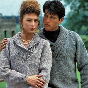 May include: A couple wearing matching grey knitted sweaters with a V-neck and a wide collar. The sweaters have a speckled pattern.