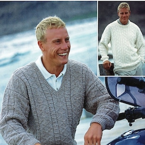 May include: A man wearing a gray cable knit sweater with a v-neck. He is sitting on a blue motorcycle with the word "YAMAHA" on the side.