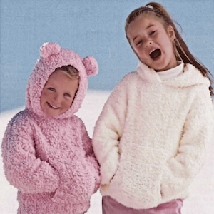 Może przedstawiać: Dwoje dzieci w bluzach z kapturem. Dziewczynka ma na sobie białą bluzę z kapturem i różowe spodnie. Chłopiec ma na sobie różową bluzę z kapturem z uszami misia i białe spodnie.