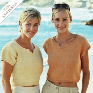 May include: Two women wearing short-sleeved knit tops with a V-neckline. The top on the left is a pale yellow color and the top on the right is a peach color. Both women are wearing beige pants.