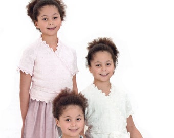May include: Three girls wearing different colored knitted cardigans with ruffled edges. The girls are wearing matching tulle skirts and are smiling at the camera.