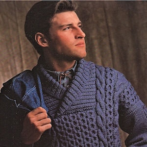 May include: A purple cable knit sweater with a wide collar. The sweater has a textured pattern and is made of a soft, warm material.