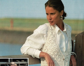 May include: A long, white crochet vest with a V-neck and button closure. The vest has a delicate, openwork pattern and is shown being worn over a white shirt.